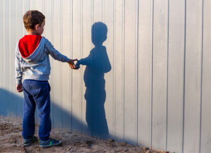 boy and his shadow. Lonely little child playing with his shadow outside. the concept of autism and loneliness. Copy space for your text
